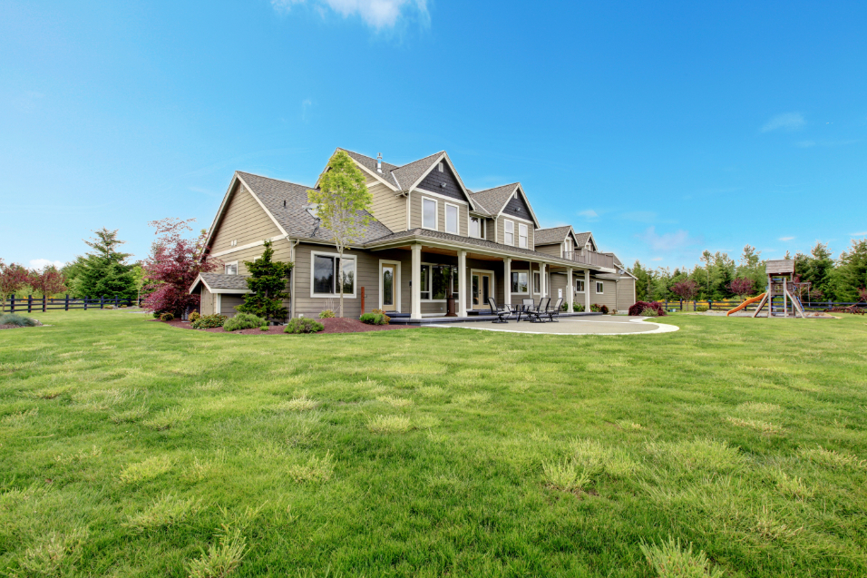 Large farm country house with spring green landscape.
