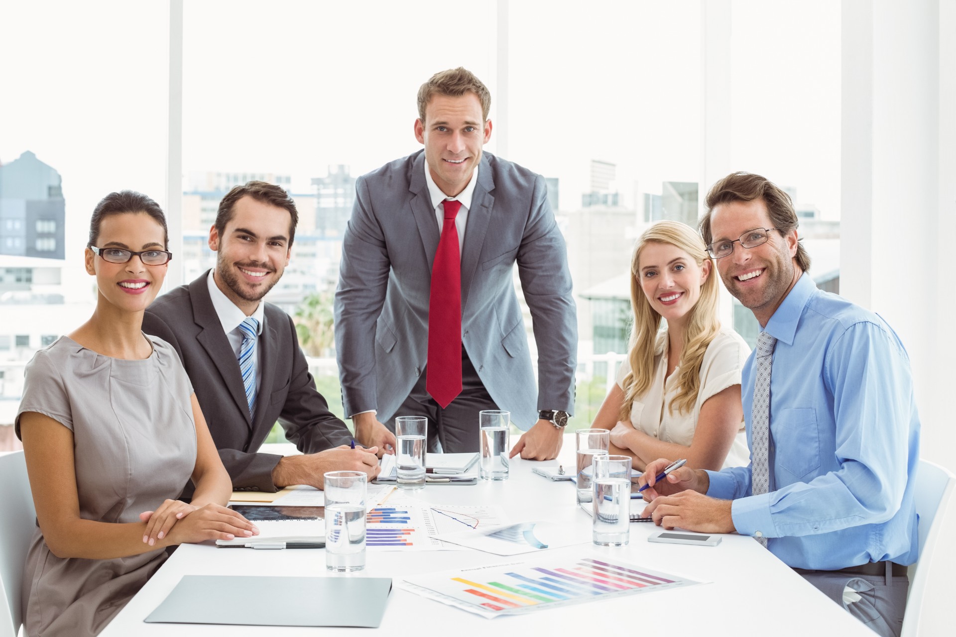 Young business people clapping hands in board room meeting at office