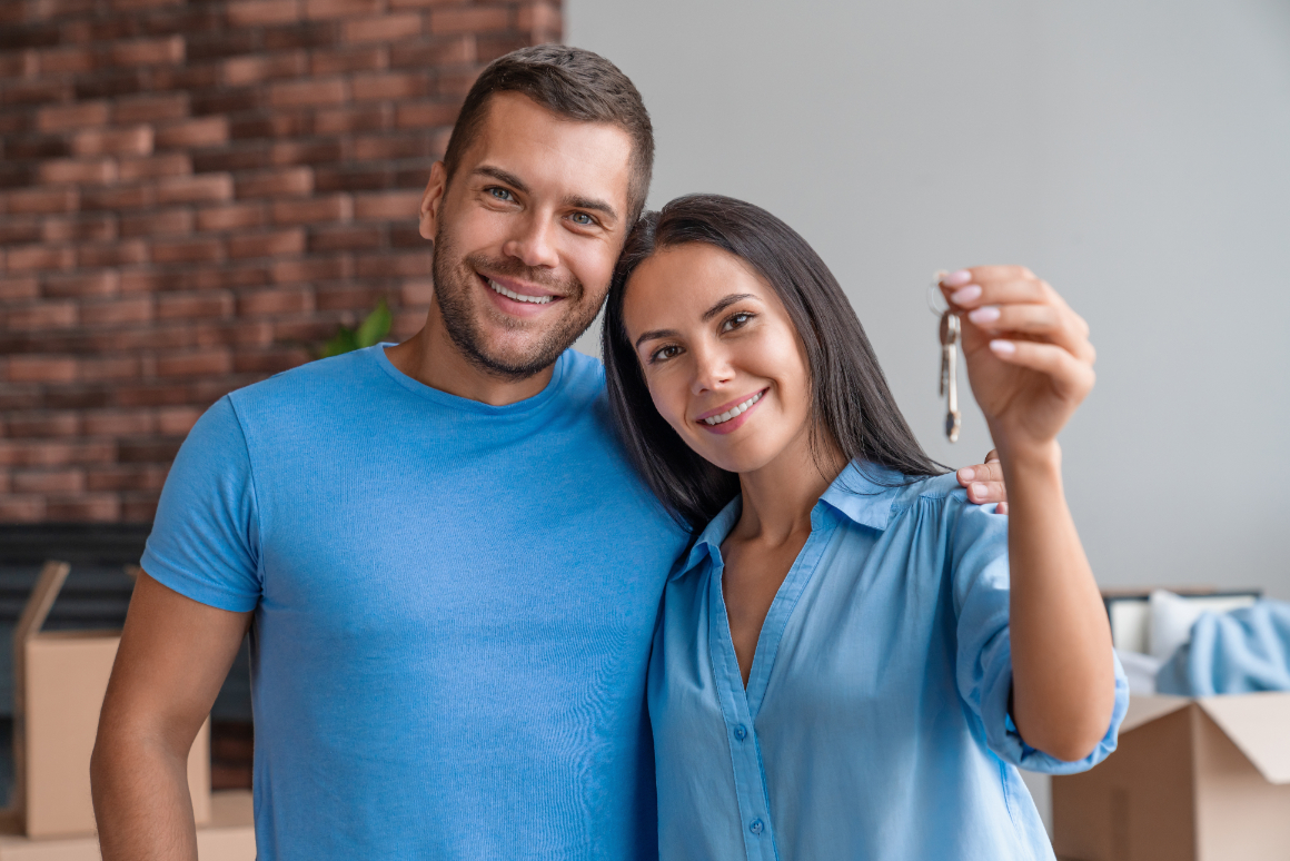 Portrait of young happy couple showing keys from new home